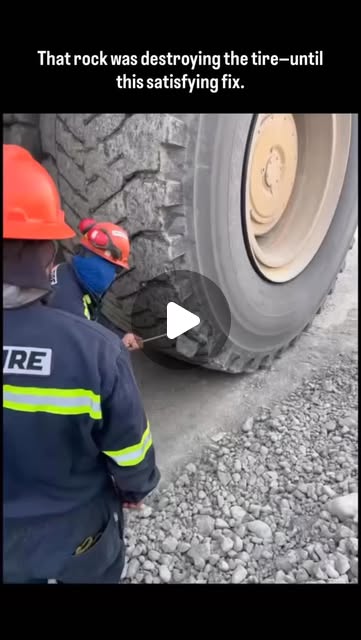 This clip shows workers using a long metal rod to carefully pry a large rock wedged deep inside the …